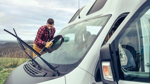 Man cleaning the best RV windshield wiper blades