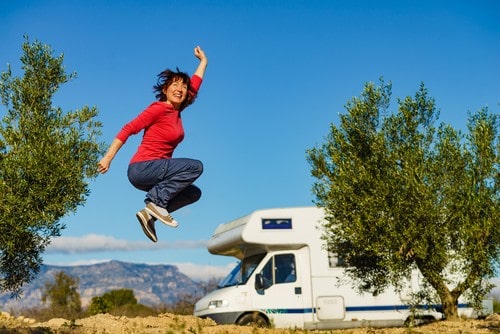 Person jumping for joy in front of an RV