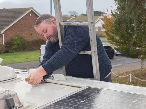 man using the best rv roof sealant on his rv