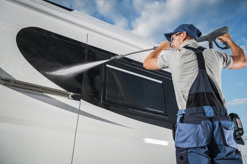 Man power washing an RV